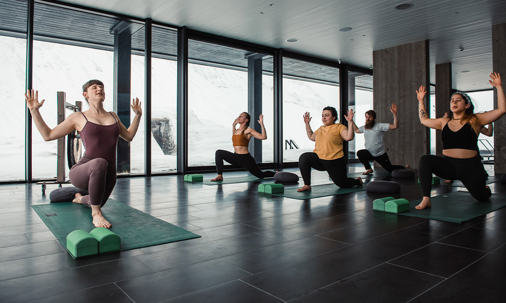 people do yoga with view of snow covered mountains out window in iceland
