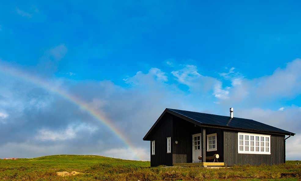 view of rainbow over eleven holkna cabins iceland