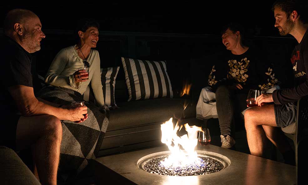 people hangout by bonfire on the roof at eleven revelstoke lodge, revelstoke, british columbia, canada