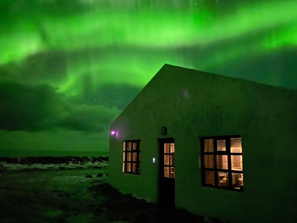 the northern lights shine over Floki Studio in Iceland