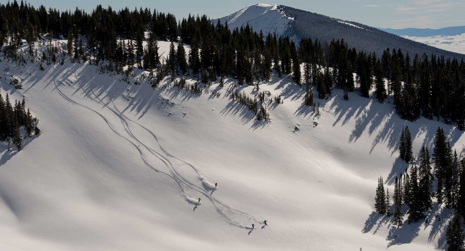 aerial view of skiers making turns in the open colorado backcountry