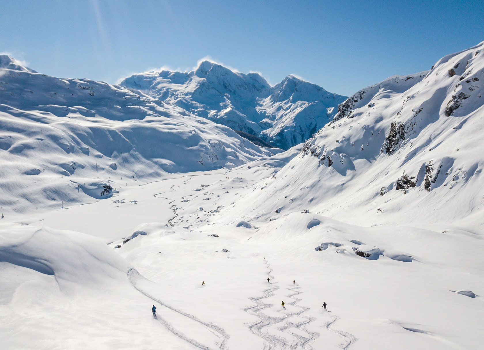 skiers make turns in wide open french backcountry